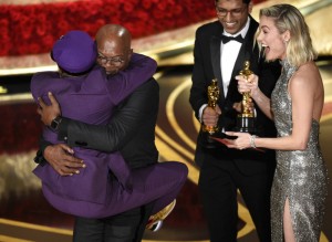 Samuel L. Jackson, center left, embraces Spike Lee, winner of the award for best adapted screenplay for "BlacKkKlansman" as Brie Larson, right, looks on, at the Oscars on Sunday, Feb. 24, 2019, at the Dolby Theatre in Los Angeles. (Photo by Chris Pizzello/Invision/AP)